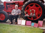 Sitting with his many trophies and Awards in front of his Nuffield Model 1060 Tractor.