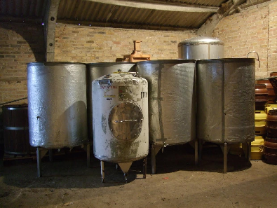 Four open top Fermenting Vessels in a row, named MUMSIE after his wife and MELLY, MADDIE and COLLY after his daughters.The smaller vessel in the front and the taller one behind are closed top Conditioning Tanks.