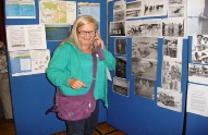 Sandra (Cornwell) Rowland beside Laurie Street’s 1953 Flood Memorial photos