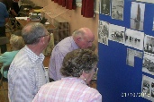 Roger Myles-Hook, Laurence Street and Marie Sutton studying Laurence Street's 1953 Flood Photographs